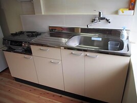 Una cocina con un lavamanos de acero inoxidable, un grifo y un dispensador de jabón.