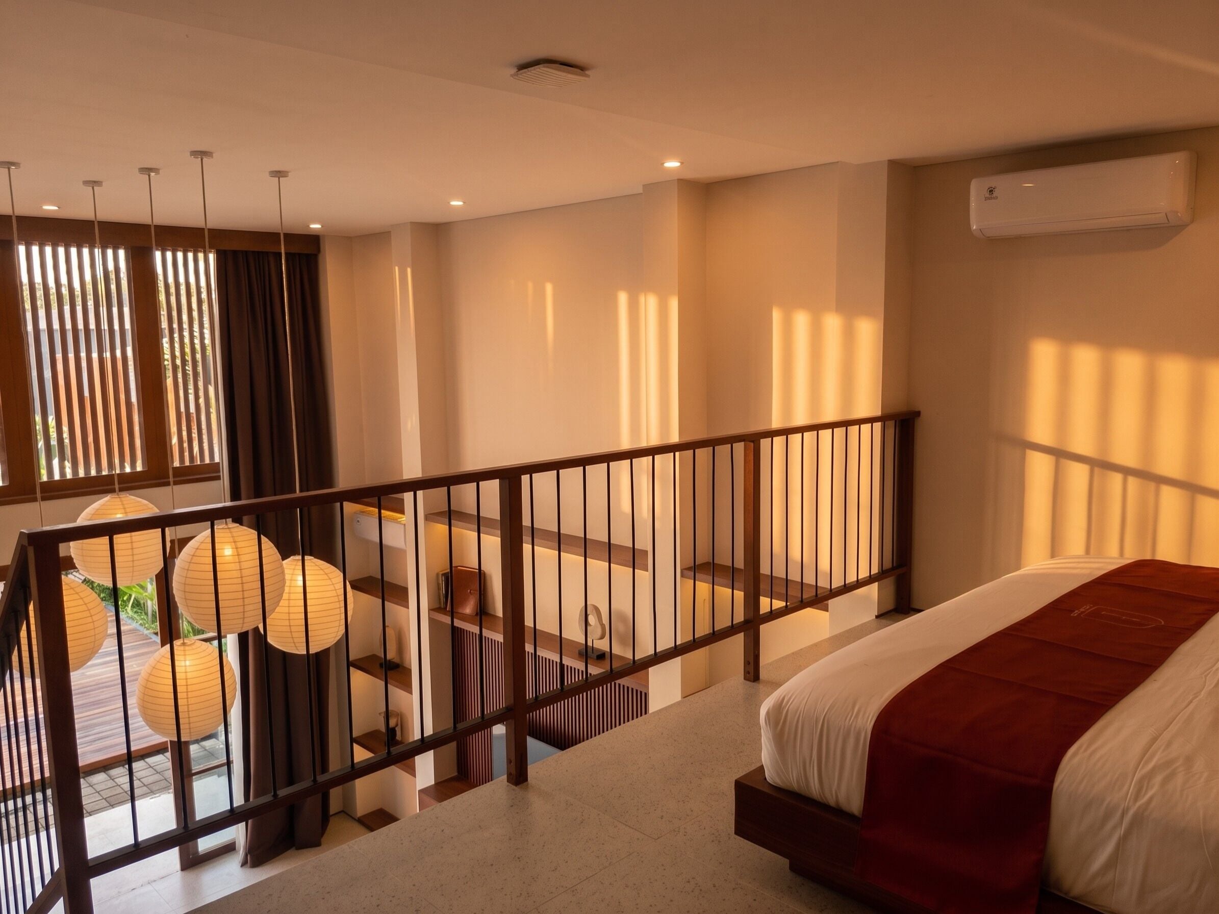 Habitación de hotel con cama, escalera y vistas al exterior.
