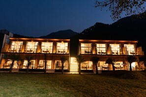 A multi-story hotel with large windows and a central staircase. - Justa Rasa Retreat & Spa Rishikesh (Yamkeshwar)