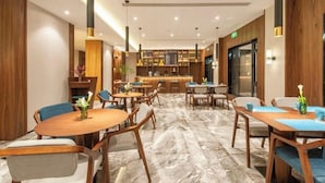 A modern hotel lobby with a bar area, seating arrangements, and a marble floor. - Ssaw Boutique Hotel Cheng Man (Shanghai)