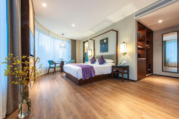 A hotel room with a bed, bedside table, a desk with a chair, a large window with curtains, a mirror, and a wall-mounted artwork. - Ssaw Boutique Hotel Cheng Man (Shanghai)