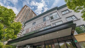 A hotel with a modern facade, large windows, and a sign indicating it is a boutique hotel. - Ssaw Boutique Hotel Cheng Man (Shanghai)