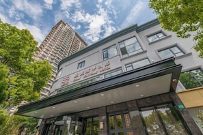 A hotel with a modern facade, large windows, and a sign indicating it is a boutique hotel. - Ssaw Boutique Hotel Cheng Man (Shanghai)