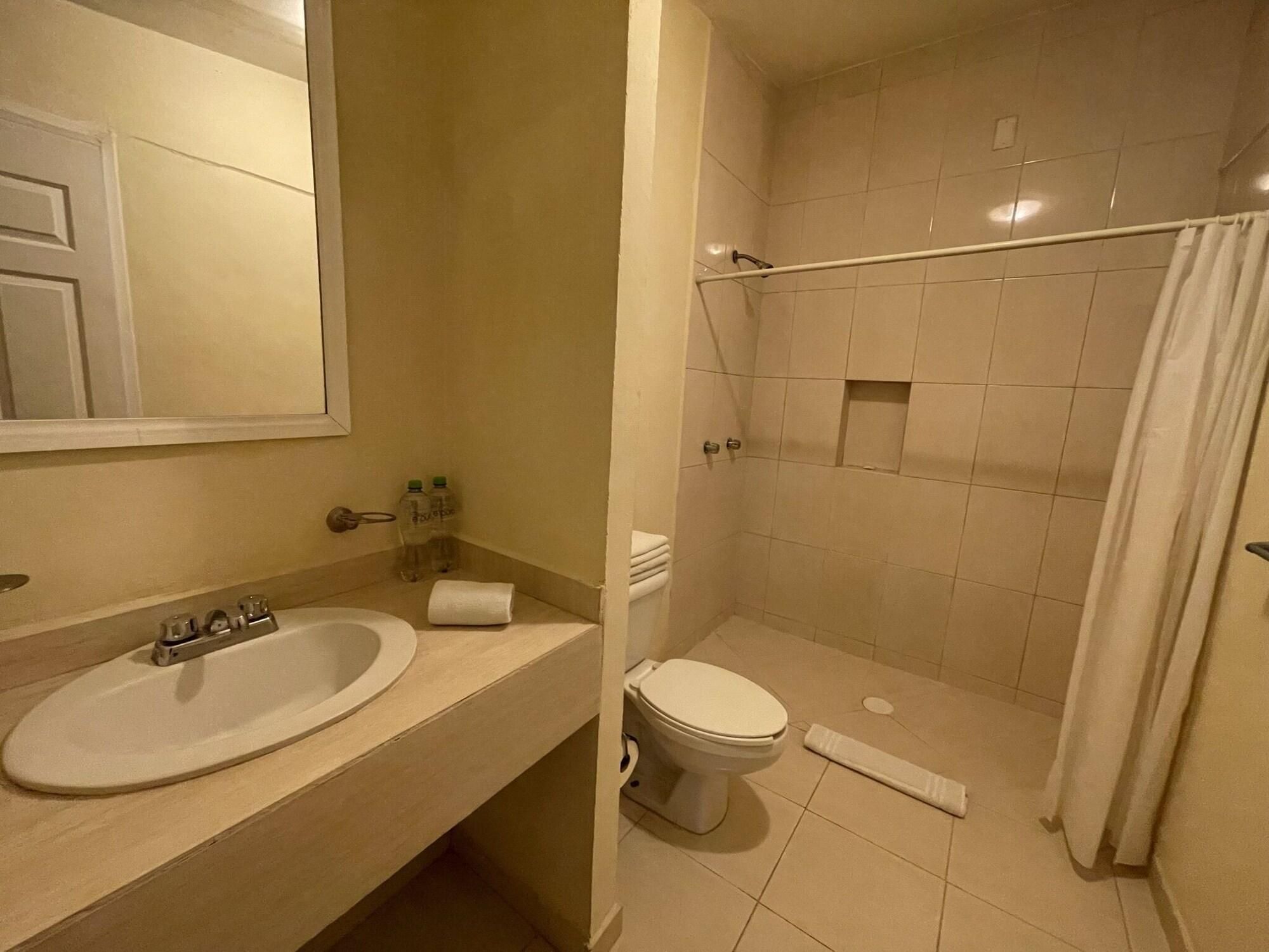 Un baño con lavabo, inodoro y zona de ducha.