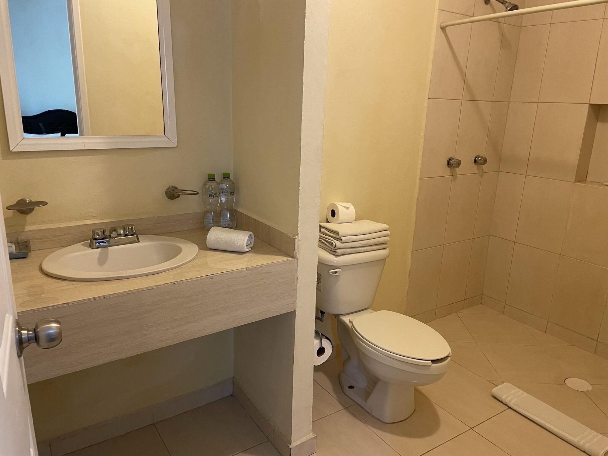 Un baño con lavamanos, inodoro y ducha.