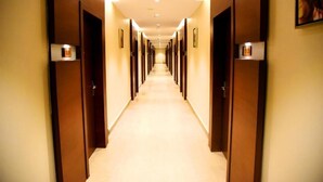 A hotel hallway with doors numbered 101 and 115, leading to rooms. - Mango Hotels Vybrant Vijayawada by Othpl (Vijayawada)