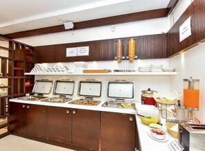 A buffet area with multiple food dispensers, a self-service beverage station, and a variety of breakfast items. - Mango Hotels Vybrant Vijayawada by Othpl (Vijayawada)