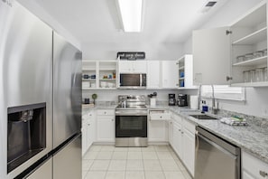 A modern kitchen with stainless steel appliances, white cabinetry, and a built-in microwave. - Condo in Barefoot Resort & Golf in North Myrtle Beach, SC. (North Myrtle Beach)