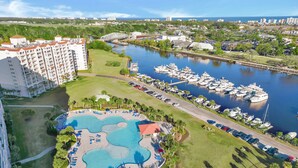 Een resort met een groot zwembad, een jachthaven en hoge gebouwen.