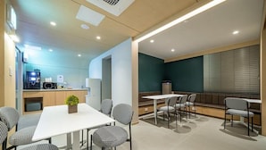 Una habitación de hotel moderna con comedor, kitchenette y zona de estar.