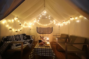 A cozy tented room with a checkered tablecloth, two cushioned chairs, a small table with food and drinks, and string lights. - Dongnae Hound Hotel Sajikminam Station (Busan)