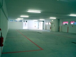 Un estacionamiento con varios niveles, espacios delimitados y salidas de emergencia.