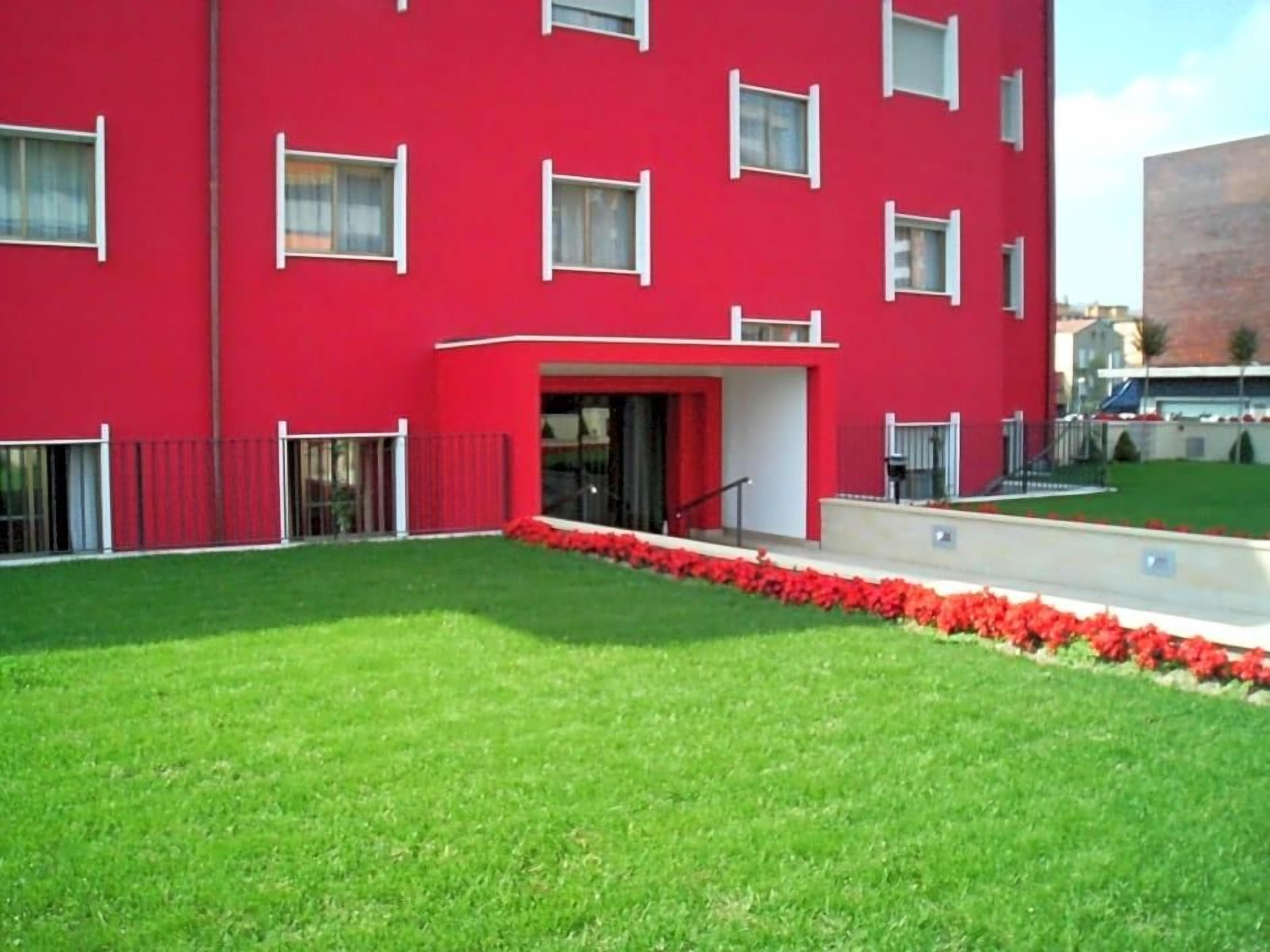 A red building with multiple windows and a small entrance.