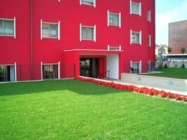 Un edificio rojo con varias ventanas y una entrada pequeña.