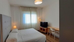 A hotel room with a bed, a television, a desk, and a chair. - Delta Hotel (San Donato Milanese)
