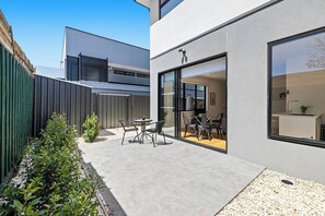 A modern building with a patio area featuring outdoor seating.