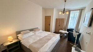 A modern bedroom with a large bed, bedside lamp, wardrobe, and a desk with a chair. - Hotel Zlatvo K Ov (Teplice)