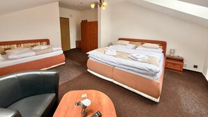 A hotel room with two beds, a desk, a chair, a wardrobe, and a chandelier. - Hotel Zlatvo K Ov (Teplice)
