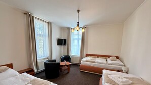 A hotel room with two beds, a sofa, a TV, and a table. - Hotel Zlatvo K Ov (Teplice)