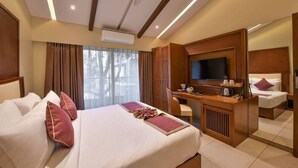 A hotel room with a bed, a desk, a television, and a mirror. - Arova Woods Zinc Journey by The Fern, Lonavala (Mawal)