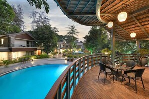 Una piscina con cubierta de madera y zona de estar al aire libre.