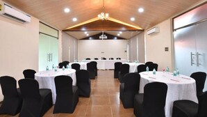 A conference room with round tables, black chairs, and a wooden ceiling. - Arova Woods Zinc Journey by The Fern, Lonavala (Mawal)