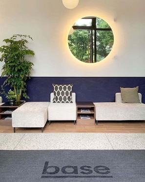 A reception area with a circular window, a potted plant, and a reception desk. - Baseplus-binjiang Serviced Apartment (Shanghai)
