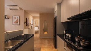 Eine moderne Küche mit schwarzem Arbeitsplatz, Edelstahlgeräten und Holzboden.