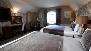 A hotel room with two beds, a desk, a chair, a television, and a window with curtains. - The Holyrood Hotel (Bundoran)