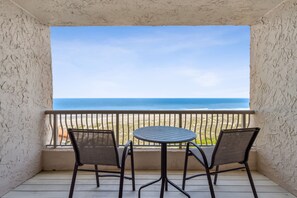 Un balcon avec vue sur la plage et l’océan.