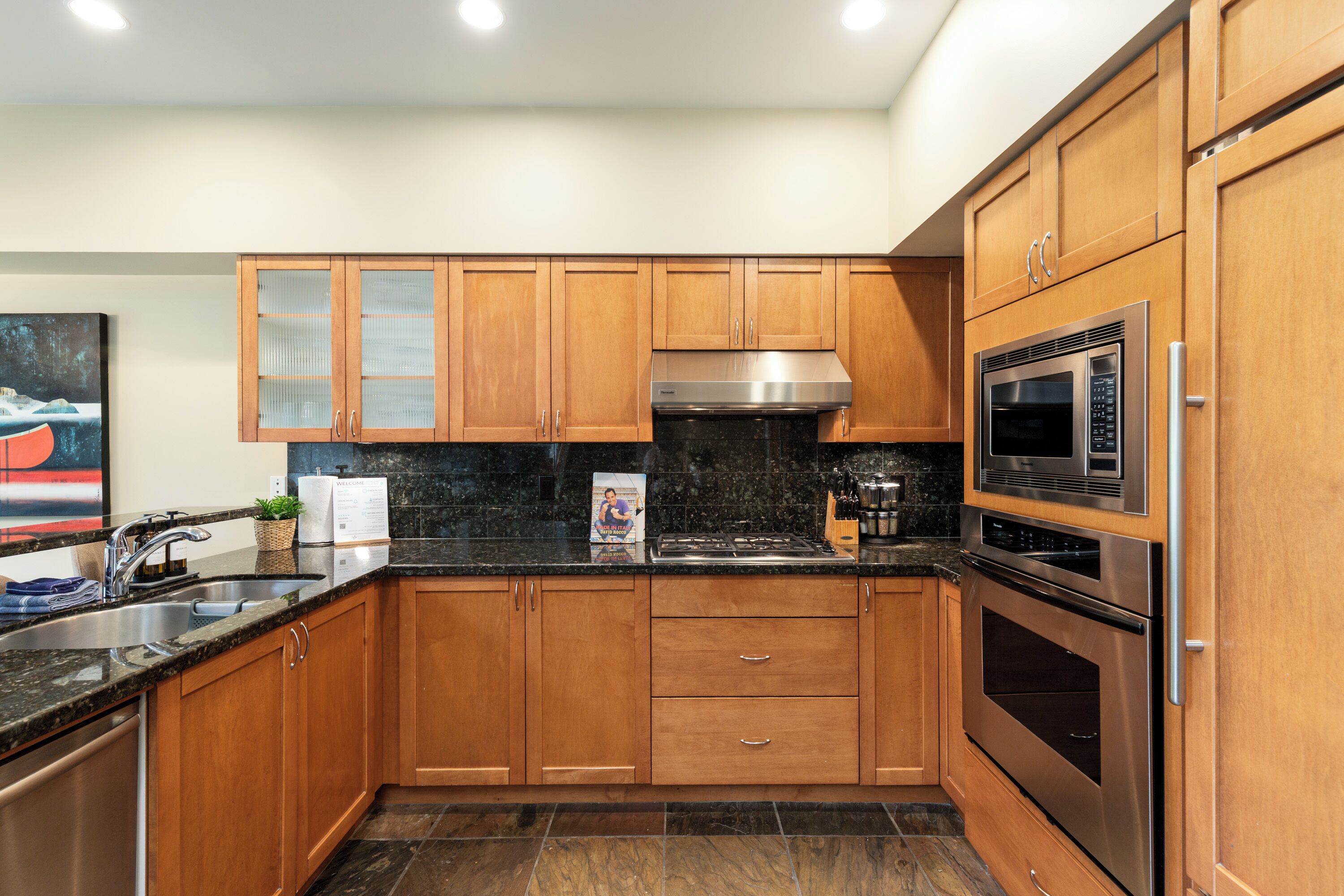 Una cocina moderna con armarios de madera, electrodomésticos de acero inoxidable y encimera de granito.