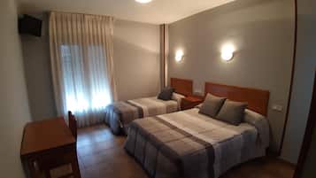 Habitación de hotel con dos camas, un escritorio y una silla.