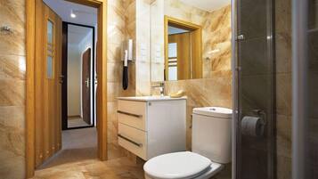 Un baño moderno con inodoro, lavamanos y ducha.