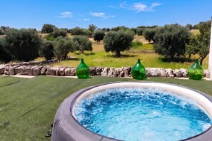 A hot tub with a view of olive trees and a stone wall. - Masseria Le Mesolecchie - Salvia Apt, Crispiano, Italy (Crispiano)
