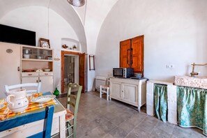 A compact kitchen with a dining area, featuring a microwave, cabinets, and a sink. - Masseria Le Mesolecchie - Salvia Apt, Crispiano, Italy (Crispiano)