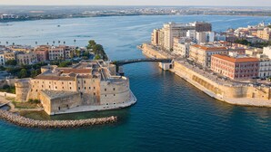 En kuststad med en imponerande historisk befästning, moderna byggnader och fri utsikt över havet.