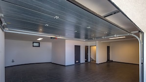 A spacious, empty hallway with a high ceiling, dark floor tiles, and a metal garage door. - Pool Villa Soléa /w Panoramic Sea View, Kostrena, Croatia (Kostrena)