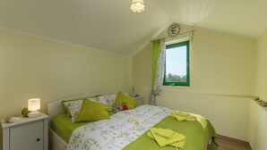 A bedroom with a bed, nightstand, lamp, and a window with curtains. - Holiday Home Ruby, Polje, Croatia (Polje)