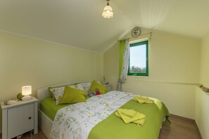 A bedroom with a bed, nightstand, lamp, and a window with curtains. - Holiday Home Ruby, Polje, Croatia (Polje)