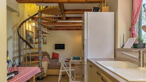A compact kitchen with a refrigerator, a sink, and a dining area with a table and chairs. - Holiday Home Ruby, Polje, Croatia (Polje)