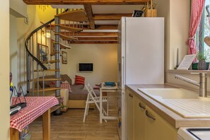 A compact kitchen with a refrigerator, a sink, and a dining area with a table and chairs. - Holiday Home Ruby, Polje, Croatia (Polje)