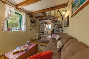 A cozy living room with a sofa, a wooden coffee table, and a window with curtains. - Holiday Home Ruby, Polje, Croatia (Polje)