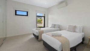 A bedroom with two beds, a window, and a view of the outdoors. - Domi Rentals - The Atkinson Home (Chadstone)