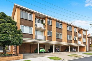 A multi-story residential building with a covered parking area. - Domi Rentals - The Balaclava Den (Saint Kilda East)