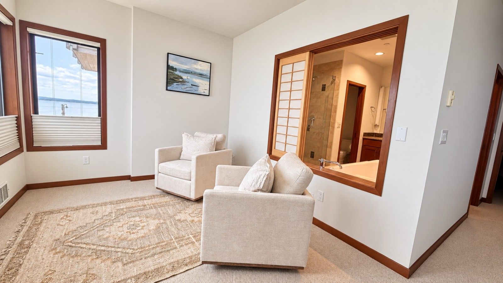 A living room with two armchairs, a large window with blinds, a rug, and a painting on the wall.