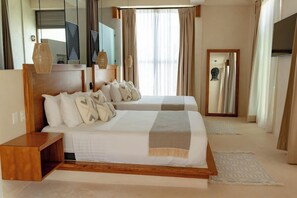 A hotel room with two beds, a wooden headboard, a bedside table, a mirror, a TV, and a window with curtains. - Joanza by OOL Hotels (Isla Holbox)