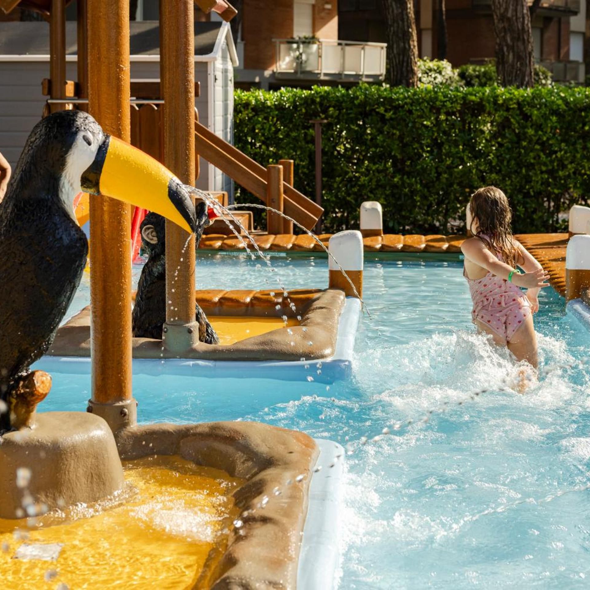 A water play area with a penguin-shaped water feature and a pool.