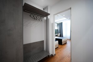 Una habitació d'hotel moderna amb un disseny minimalista, que compta amb un llit gran, una zona de seients i vista cap a l'habitació veïna.