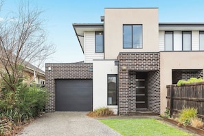 A modern two-story house with a garage, a brick facade, and a small front yard. - Domi Rentals - The Third Residence (Clayton South)