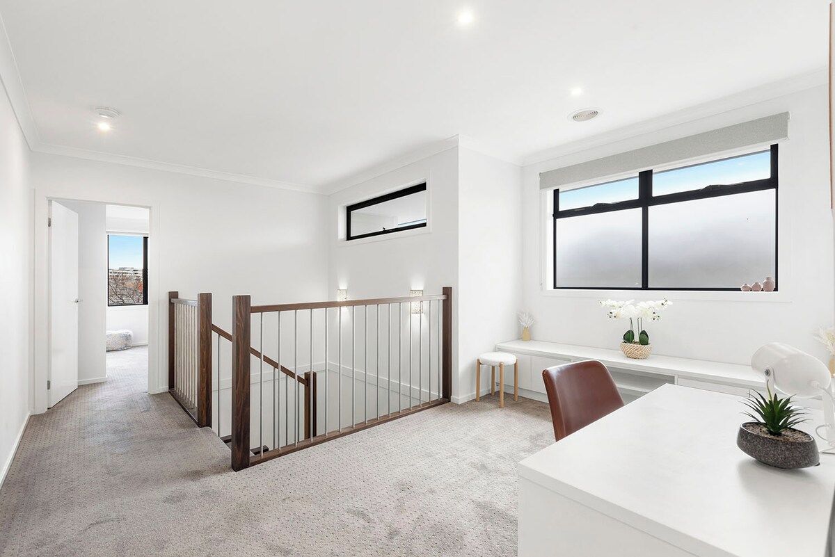 A modern interior with a staircase, a desk, and a window with a view.